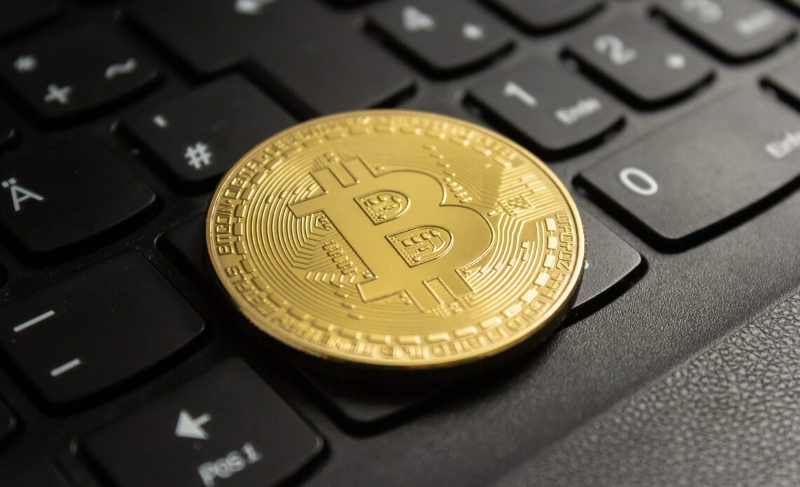 Closeup shot of a bitcoin put on a black computer keyboard